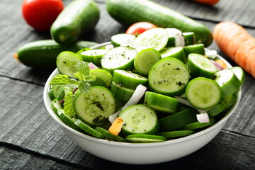 Bowl of fresh cucumber salad with  herbs and oil