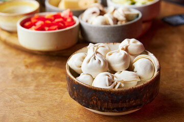Fototapeta na wymiar raw dumplings in a wooden bowl close-up