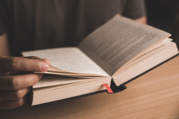 Young man reading a book or holy bible and sharing the gospel in living room. 