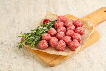 Raw uncooked beef meatballs served rosemary