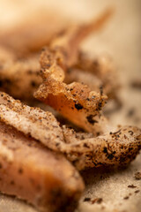 thinly sliced homemade lard with pepper on white oiled paper, close-up, selective focus.