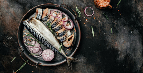 Atlantic mackerel fish on dark background. Healthy food, diet or cooking concept. Long banner format. top view