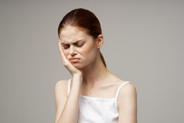 woman holding on to face pain in teeth studio treatment