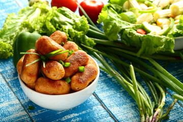 Bowl of spicy cocktail sausages and salads.