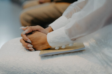close up of a bride holding hands praying in her wedding matrimony