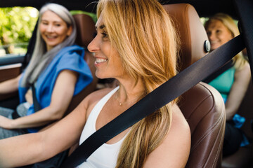 Fototapeta na wymiar Multiracial women laughing and talking in car after practice