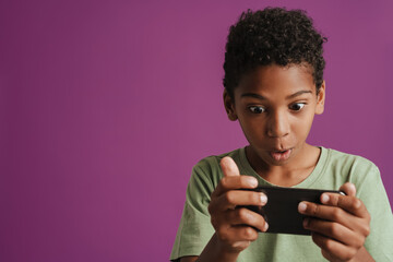 Black boy wearing t-shit playing online game on mobile phone