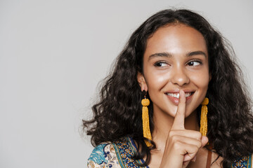 Young south asian woman wearing earrings showing silence gesture