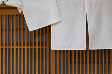 日本料理店の入口の格子戸と風でめくれ上がった白い暖簾