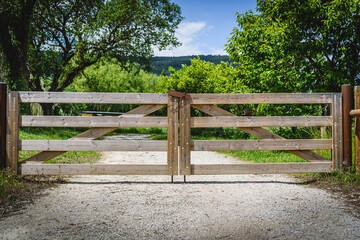 Wooden gate in the countryside (gravel road).