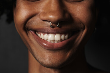 Young black man in t-shirt smiling while showing heart gesture