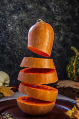Levitation pumpkin on a background of seeds and autumn leaves. Simple composition, rustic style
