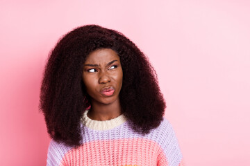 Photo of unsatisfied dark skin girl sullen face look empty space wear sweater isolated on pink color background