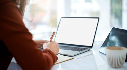 Focus on hand young asian woman writing on book and using computer laptop and tablet working or study online