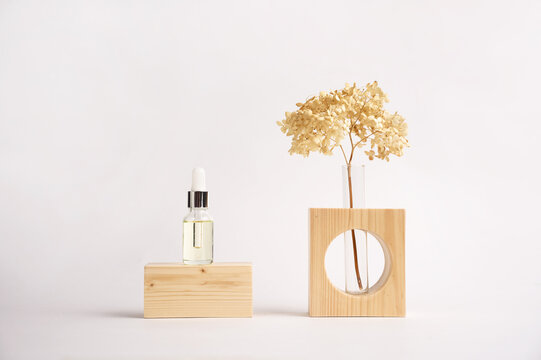 Wooden podium with cosmetic bottle, dried flower in the vase on grey background for product presentation.