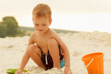 Little boy resting on a sandy beach