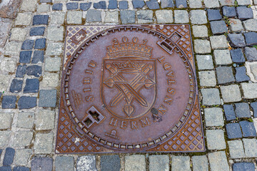 A manhole cover with coat of arms of Sibiu in Romania