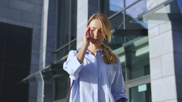 Concerned blond woman in casual shirt putting off eyeglasses and touching crumped temple, feeling dizziness and headache, suffering high blood pressure, menopause symptoms, overworking