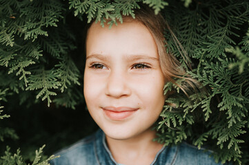 portrait of the face of a cute happy caucasian candid healthy eight year old kid girl surrounded by...