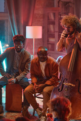 Group of musicians drinking alcohol during their performance in the club