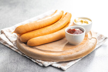 Smoked frankfurter sausages on cutting board.