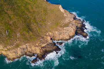 Ocean waves splash against rock on island