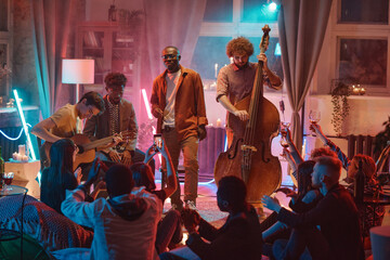 Guys playing on different musical instruments for people during their performing in the night club