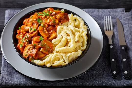 spaetzle with mushroom gravy in a black bowl