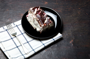 Plate with slice of tasty chocolate cake on table. Yummy dessert on on wooden background, closeup