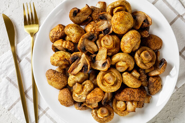 grilled juicy mushrooms on a plate, top view