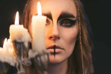 portrait of a witch with candle. Halloween mystical atmosphere. Celtic mythology goddess Valkyrie....
