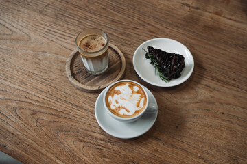 Latte art coffee on wooden table in coffee shop