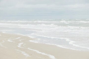 Küste mit Meer, Wellen und Sand, verschwommen