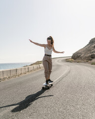 Young girl riding a skateboard with beige pants and white t-shirt