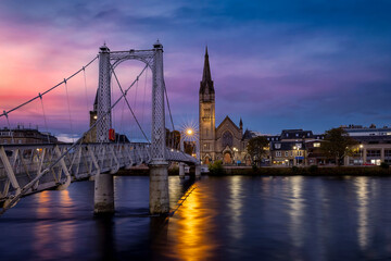 Beautiful, illuminated cityscape of Inverness with Greig Street Bridge and River Ness during sunset, Scotland