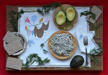 Plate of elvers (or gulas) on a tablecloth with avocados and bread