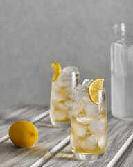 Homemade lemonade with ice in glasses on a wooden table