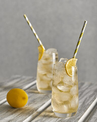Homemade lemonade with ice in glasses on a wooden table