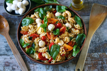 Pasta with mozzarella balls and tomatoes. Italian mood. Healthy food.