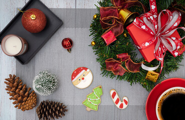 Christmas dinner table decorations with a cup of coffee, sugar coated biscuits, and scented candles.