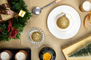 Top view of a Christmas table settings with gold color baubles.