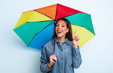pretty hispanic woman feeling like a happy and excited genius after realizing an idea. umbrella...