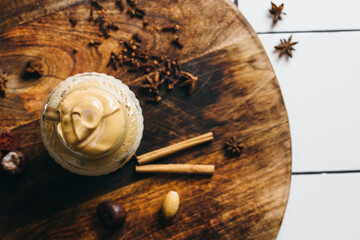 Homemade Dalgona coffee in a mason jar. Autumn vibe. Cinnamon and star anise. Table top. Top down.