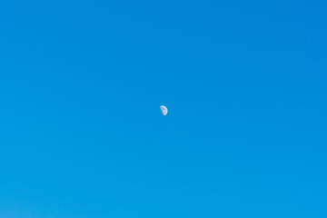 The moon against a blue summer sky.