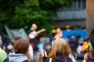 Crowd enjoying and clapping a street public rock concert