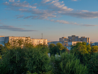 Obraz premium Urban houses and green trees in the morning sun.