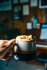 Homemade Dalgona coffee in seventies ceramic cup. Trendy and arty cafe VSCO style.