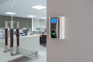 Finger print scan machine on wall near entrance door office.