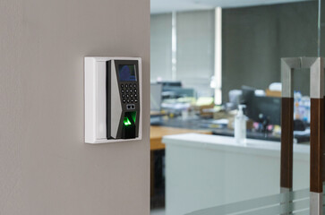 Finger print scan machine on wall near entrance door office.
