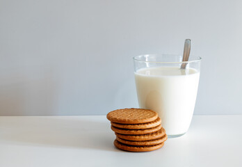 Glass of milk and six round butter biscuits